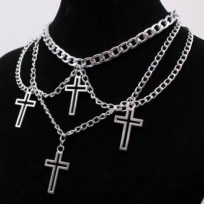 Multi-layered cross necklace by eprolo featuring layered metal crosses hanging from a chain on a white background.